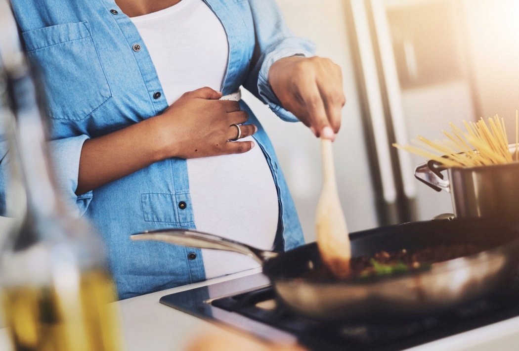 Pregnant, cooking and woman in kitchen in home