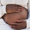 african pregnant woman holding her belly