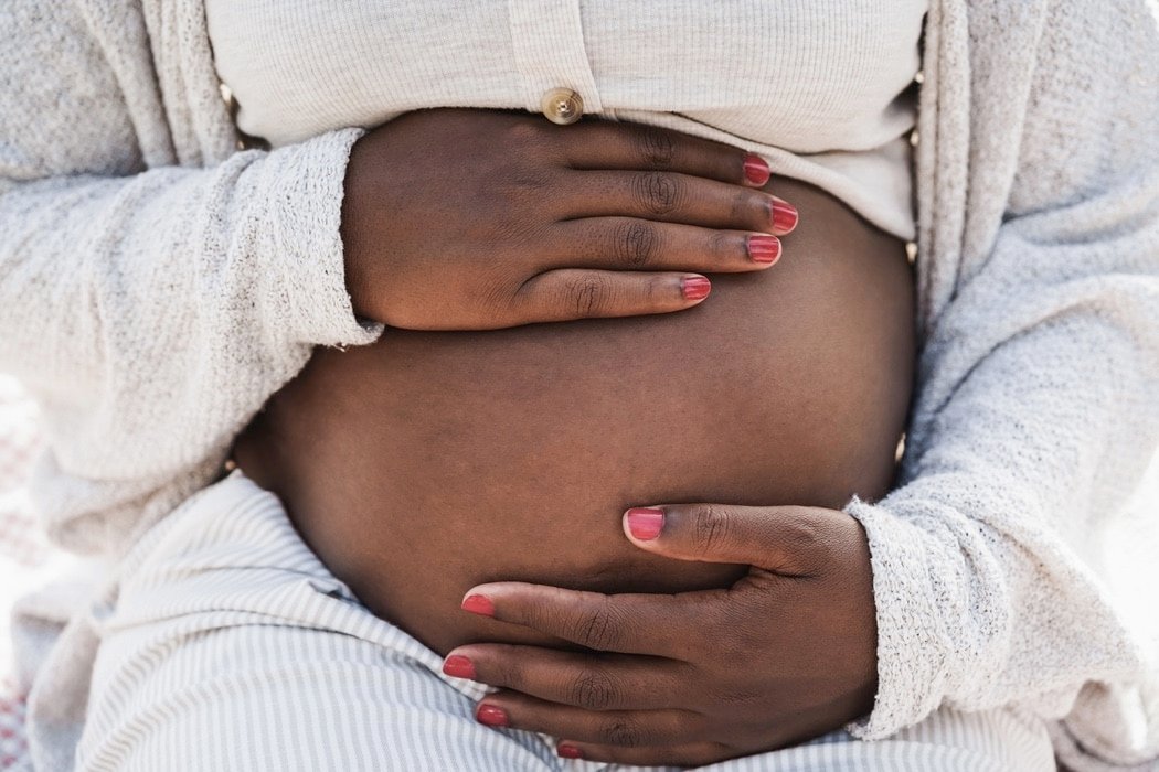 african pregnant woman holding her belly