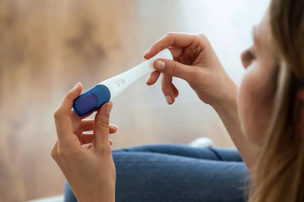 Young woman looking at pregnancy test
